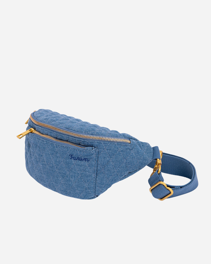 Blue denim Fawny Pack with gold zippers on a white background