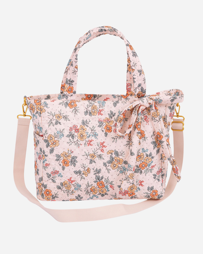 Floral patterned handbag with a strap on a white background